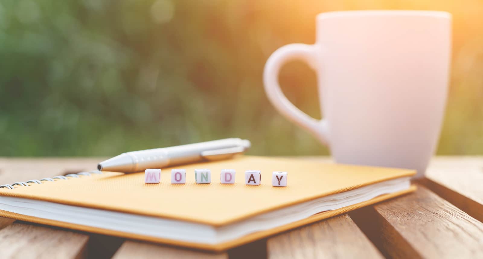 Monday written in letter beads and a coffee cup on table