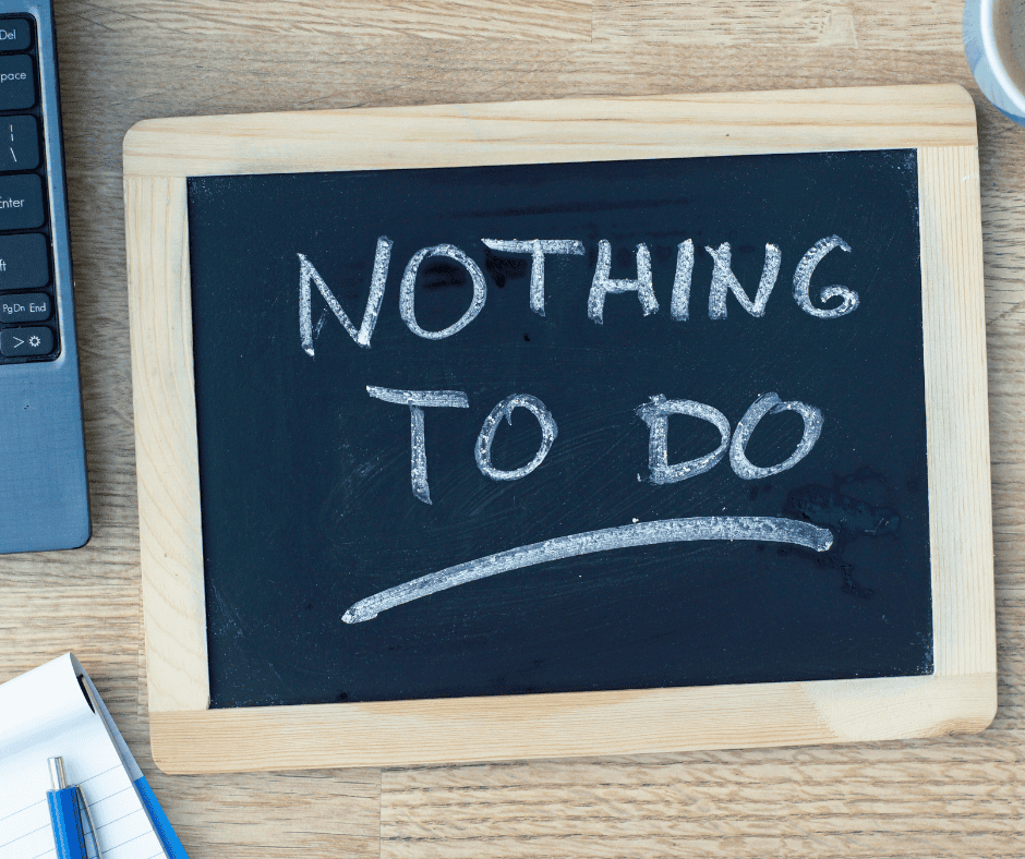 A handheld chalkboard with a maple frame that has the words NOTHING TO DO on it in white chalk.