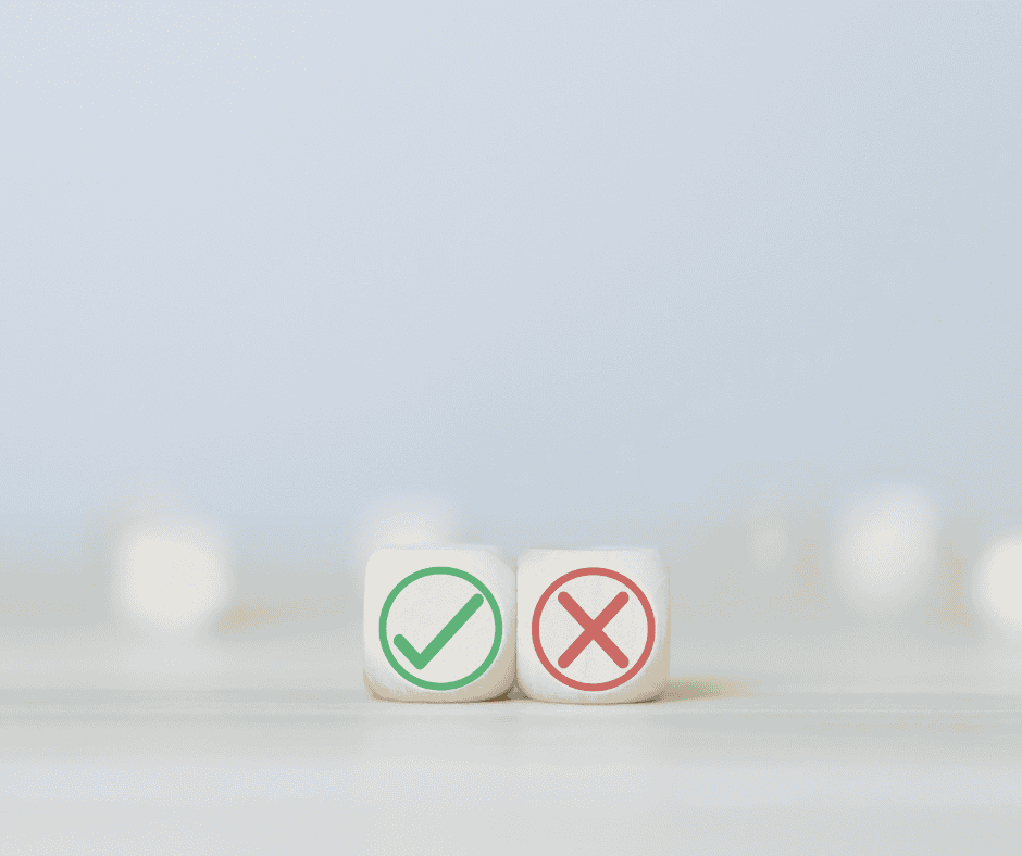 Two dice on a neutral surface, one showing a green checkmark and the other a red X, representing right and wrong.