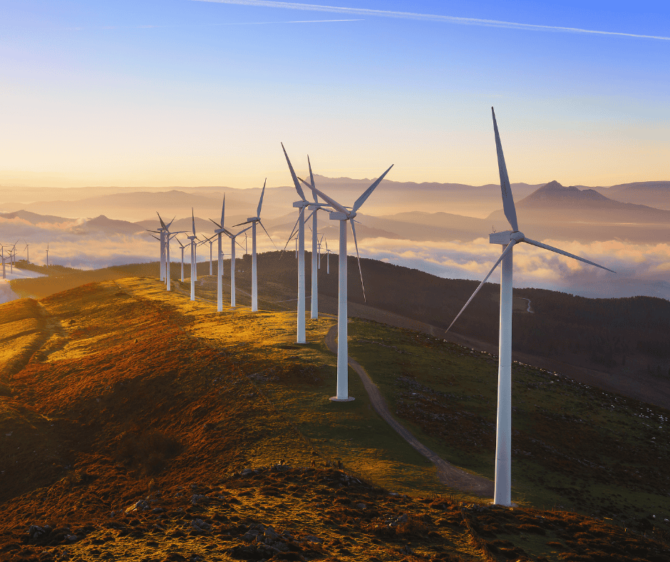 Wind turbines at sunrise over misty mountains — capturing energy that's already available, a visual metaphor for energy stewardship over time management.