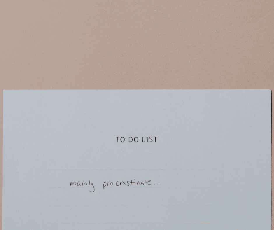 A handwritten to-do list on a soft pink background with a single honest entry — "mainly procrastinate…" — capturing why we procrastinate even with the best intentions to get things done.